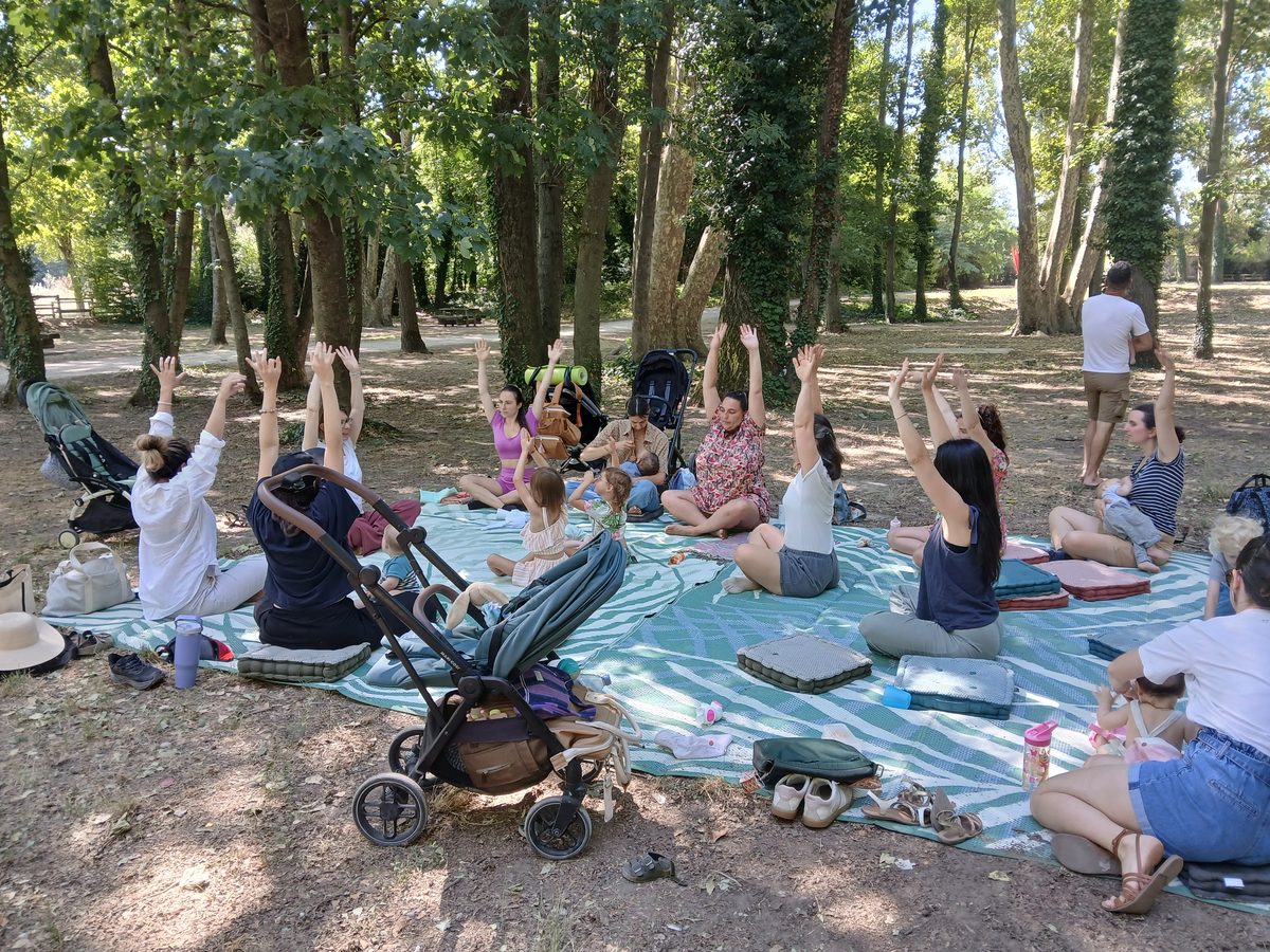 Atelier de Chemins de Naissance en plein air, parents et enfants assis en cercle sur une couverture