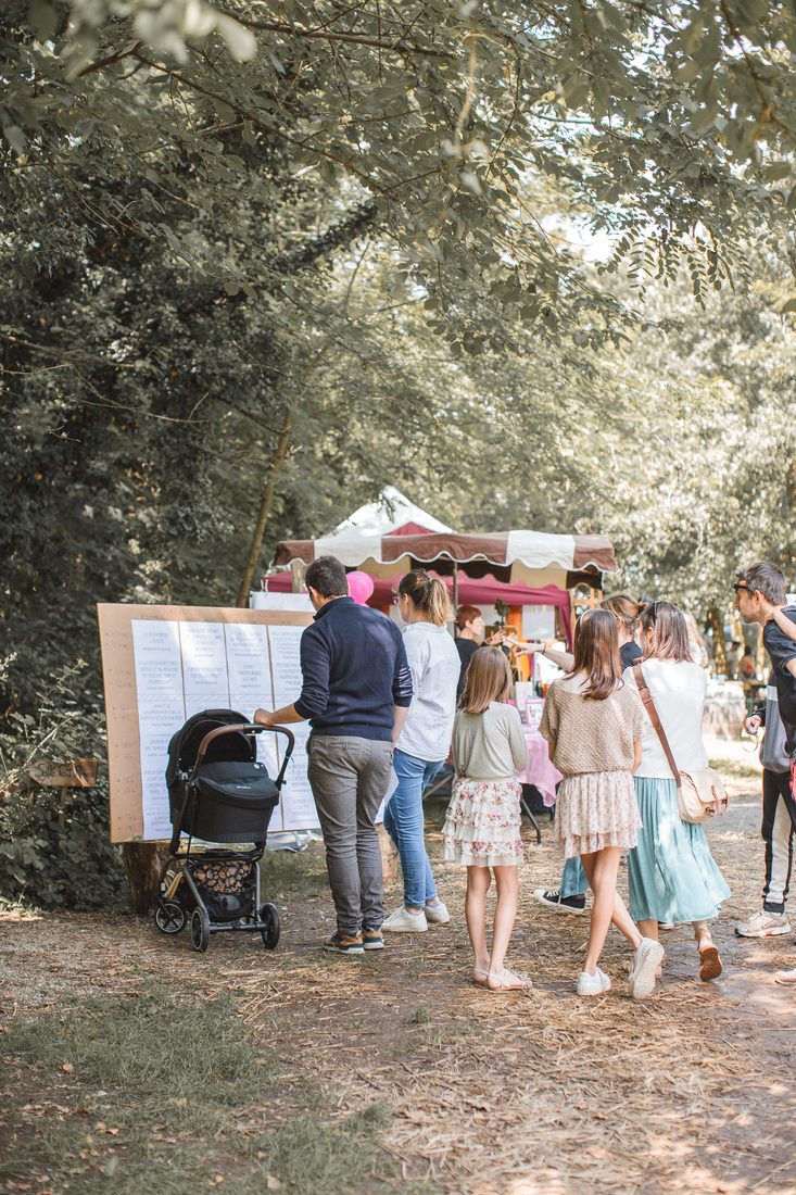 Des familles devant le programme du festival Devenir Parents 2024
